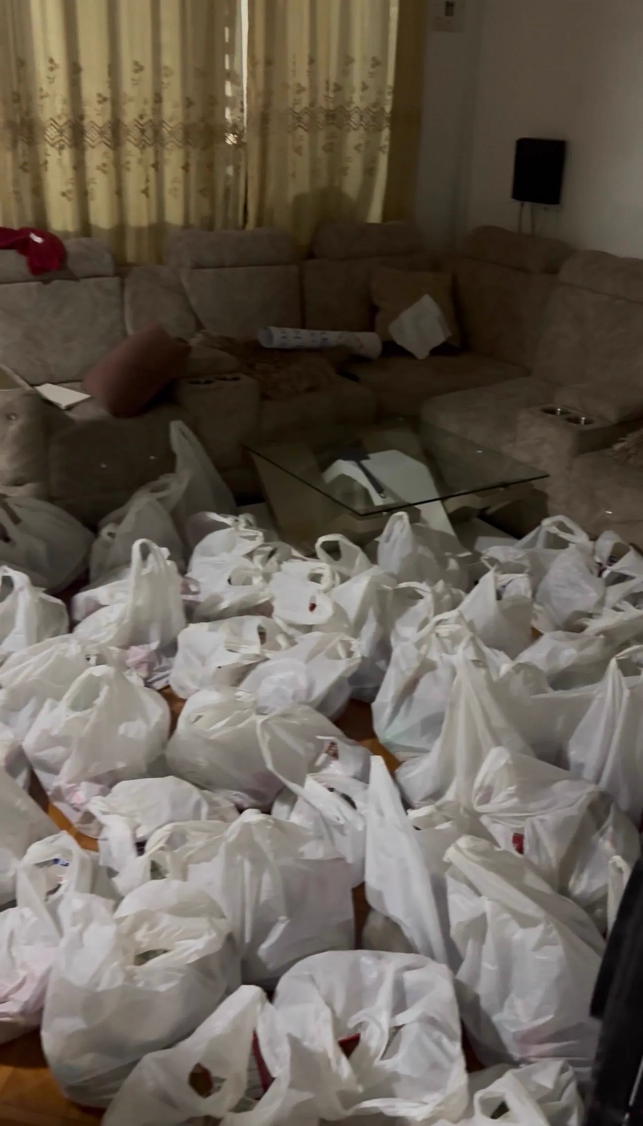 Decenas de bolsas blancas con remesas preparadas y apiladas, listas para ser entregadas a las familias damnificadas